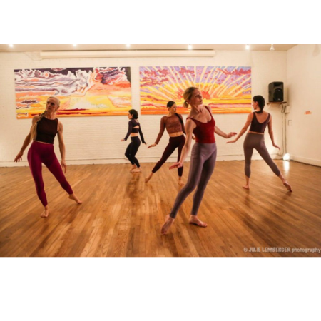 Five modern dancers on a wooden floor