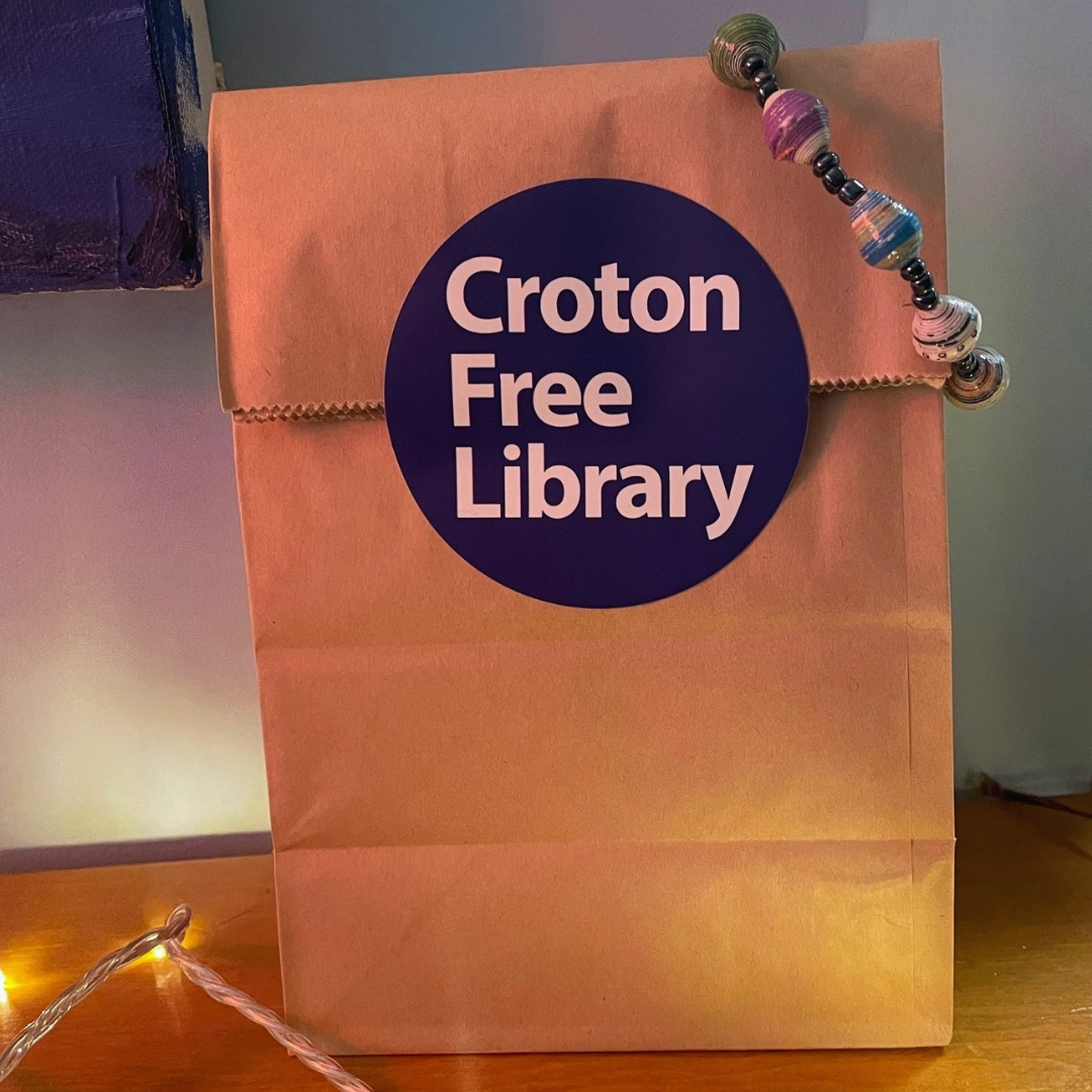 Paper bag with Croton Free Library Sticker and handmade jewelry.
