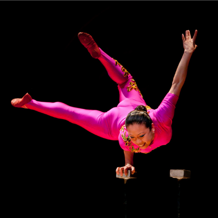 Li Liu in a pink costume, balancing