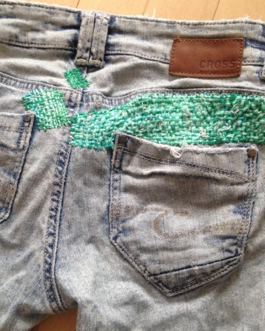 Jeans with a green mended patch